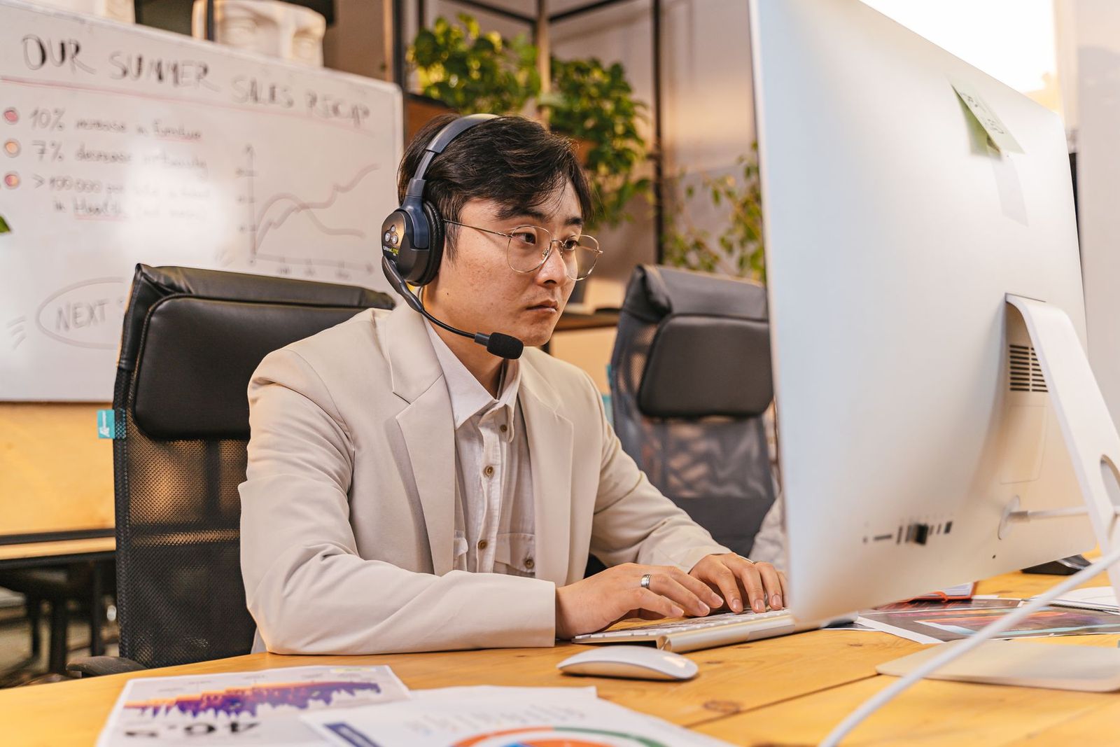 オフィスでデスクトップPCを使うスーツの男性
